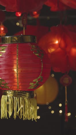 Vertical-Video-Studio-Shot-Of-Colourful-Chinese-Lanterns-Celebrating-New-Year-Hung-Against-Black-Background